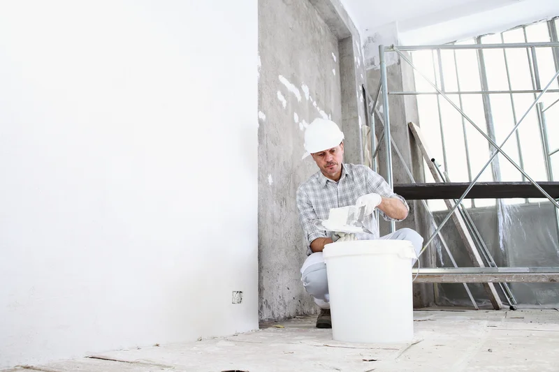 Professional plasterer prepping paint or joint compound on site Professional plasterer prepping paint or joint compound on site