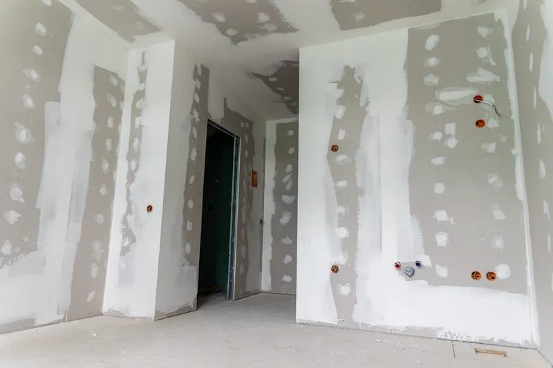 Unfinished drywall in a room prepared for professional painting services. Unfinished drywall in a room prepared for professional painting services.