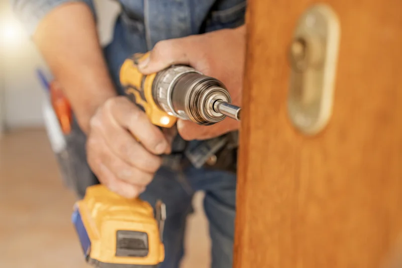 Handyman installing door hardware during home improvement project Handyman installing door hardware during home improvement project